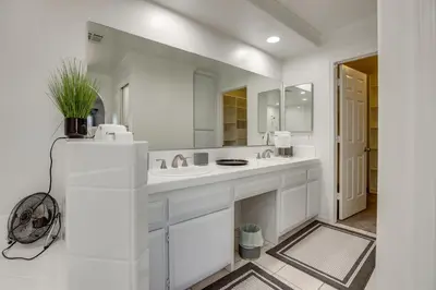 a white bathroom with a sink and a mirror at Pool, Spa and Mountain Views Apple Valley Retreat! in Apple Valley