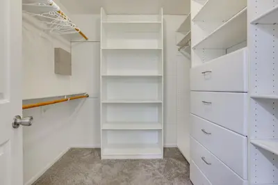 a walk in closet with white shelves at Pool, Spa and Mountain Views Apple Valley Retreat! in Apple Valley