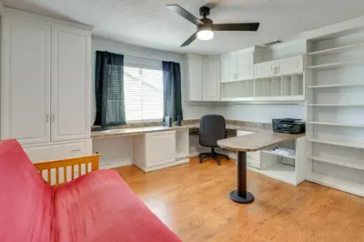 a living room with a red couch and a table at Pool, Spa and Mountain Views Apple Valley Retreat! in Apple Valley