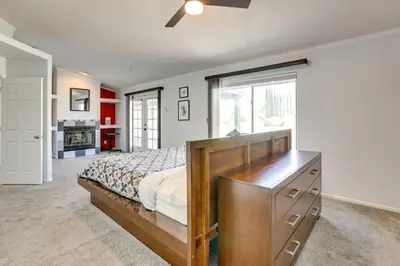 a bedroom with a bed with a dresser and a window at Pool, Spa and Mountain Views Apple Valley Retreat! in Apple Valley