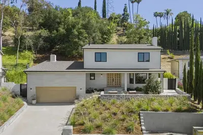 a white house with a driveway and trees at The Dona Modern in Los Angeles