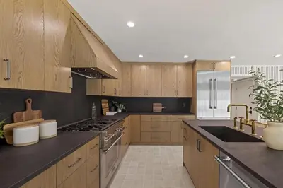 a kitchen with wooden cabinets and stainless steel appliances at The Dona Modern in Los Angeles