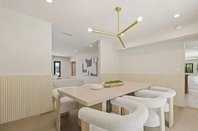 a dining room with a table and white chairs at The Dona Modern in Los Angeles