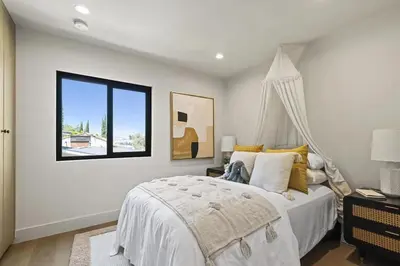 a white bedroom with a bed and a window at The Dona Modern in Los Angeles
