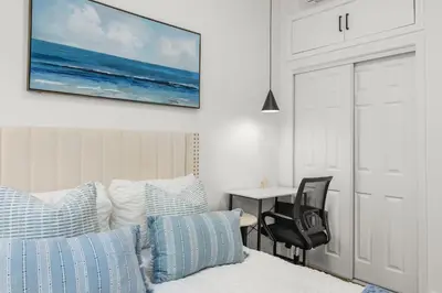 a bedroom with a bed and a chair and a table at #Marbella Lane - Cityside Haven with Touch of Charm in Compton