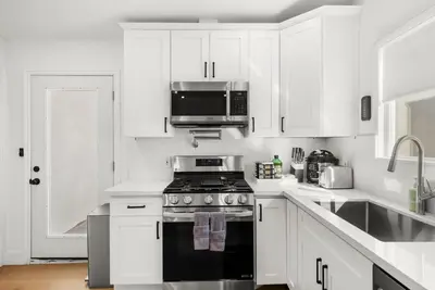 a white kitchen with a stove and a microwave at #Marbella Lane - Cityside Haven with Touch of Charm in Compton