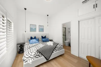a white bedroom with a bed with blue pillows at #Marbella Lane - Cityside Haven with Touch of Charm in Compton