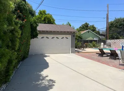 a driveway with a garage and a pool at Northridge 3BR 2BA Home with Pool on a Tree-Lined street, Close to CSUN in Northridge
