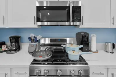 a kitchen with a stove with two bowls and a microwave at Enchanted Dreams by OC Adventure Homes in Garden Grove