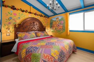 a bedroom with a bed with a colorful quilt at Enchanted Dreams by OC Adventure Homes in Garden Grove