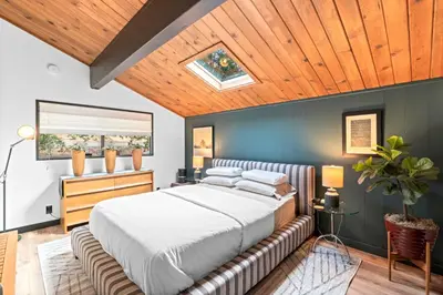 a bedroom with a large bed and a wooden ceiling at BlackOak Hideaway in Lake Arrowhead