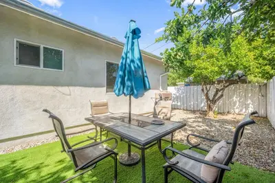 a patio with a table and chairs and an umbrella at Stay on Hart in Los Angeles
