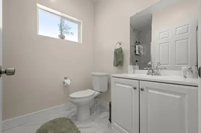 a white bathroom with a toilet and a sink at Stay on Hart in Los Angeles