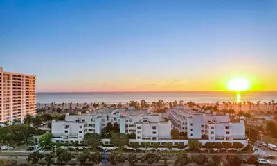 a sunset over a city with buildings and the ocean at Oceanfront Artists Retreat Santa Monica Luxury in Los Angeles