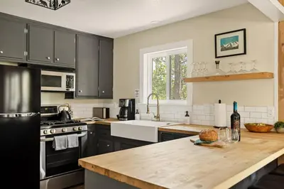 a kitchen with black cabinets and a wooden counter top at The Mountain Sanctuary in Lake Arrowhead