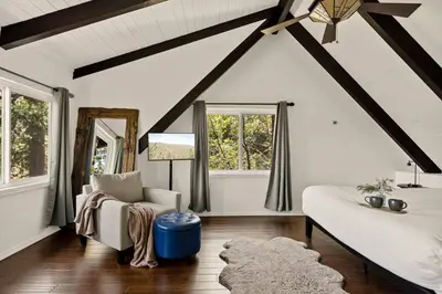 a living room with a couch and a chair and windows at The Mountain Sanctuary in Lake Arrowhead