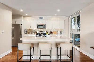 a kitchen with a large island with bar stools at Azure Marina Luxe - Waterfront with Sunset Views in Los Angeles
