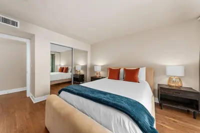 a bedroom with a large bed and a mirror at Azure Marina Luxe - Waterfront with Sunset Views in Los Angeles