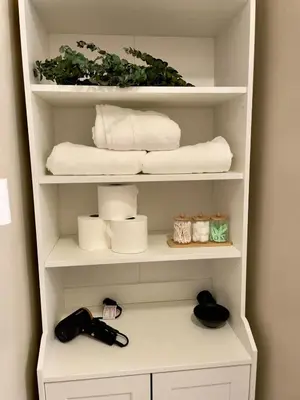 a white book shelf with towels and towels at Pasadena Quiet Gem with Fiber Internet WiFi and Workspace in Pasadena