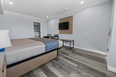 a bedroom with a bed and a flat screen tv at Downey Inn in Downey