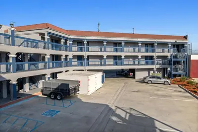 a building with a truck parked in a parking lot at Downey Inn in Downey