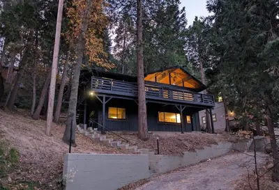 a house in the woods with a large window at Fam & Pet Friendly Chalet w AC & BBQ - Top Rated in Crestline
