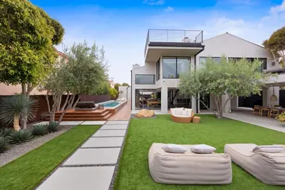 a house with a garden with two couches in the yard at The Colony Reserve by Stay Awhile Villas in Malibu Beach