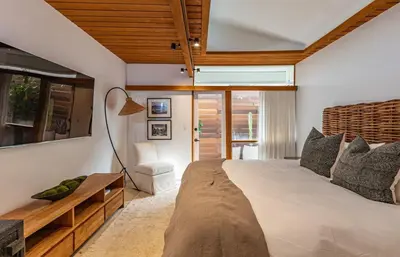 a bedroom with a large bed and a table at The Hideaway Beach House by Stay Awhile Villas in Malibu Beach