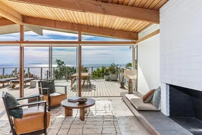 a living room with a fireplace and a view of the ocean at The Hideaway Beach House by Stay Awhile Villas in Malibu Beach