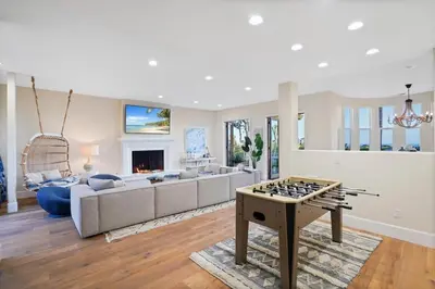 a living room with a game table in the middle at Villa Azure - by Stay Awhile Villas in Malibu