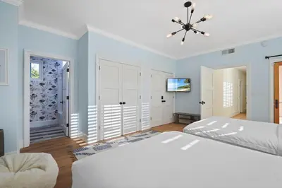a white bedroom with a bed and a ceiling fan at Villa Azure - by Stay Awhile Villas in Malibu