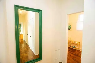 a mirror with a green frame on a wall at At Hermosa Ave and Pier Ave- C in Hermosa Beach