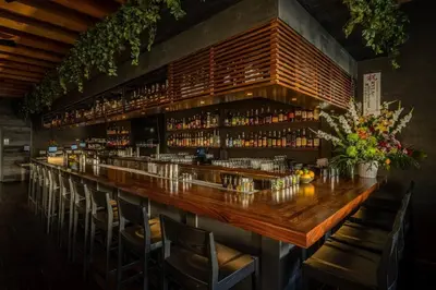 a bar with a long wooden counter and chairs at At Hermosa Ave and Pier Ave- C in Hermosa Beach