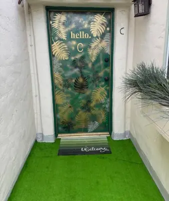 a green door with a welcome sign on it at At Hermosa Ave and Pier Ave- C in Hermosa Beach