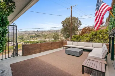 a patio with a bench and an american flag at New Listing Palisades Villa by Colby & Conrad in Los Angeles