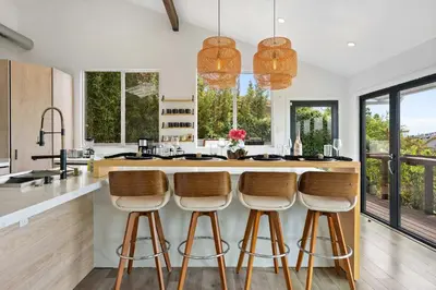 a kitchen with a large island with bar stools at New Listing Palisades Villa by Colby & Conrad in Los Angeles