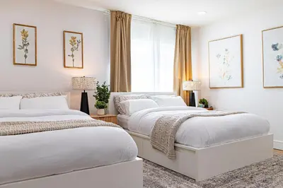 two beds in a white bedroom with a window at Grand 4-Bedroom - Brand New - Free parking and Patio in Los Angeles