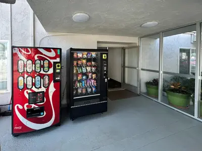 a cocacola soda vending machine in a building at Studio 6 Suites Buena Park CA Anahiem Near Maingate Knotts in Buena Park