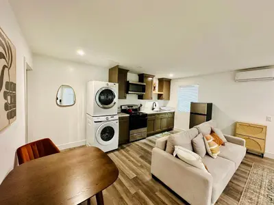 a living room with a couch and a kitchen at Modern LA Guest House in Los Angeles