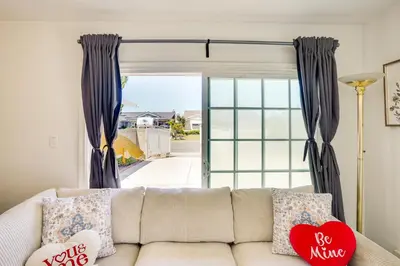 a living room with a couch in front of a sliding glass door at Explore SoCal! Cozy Retreat Near Disney and Beaches in Westminster