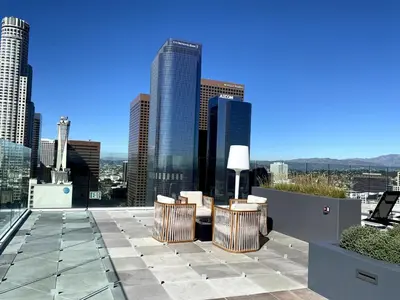 a rooftop patio with chairs and a view of the city at Luxury 1 Bedroom vacation Home in Downtown LA in Los Angeles