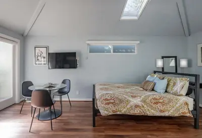 a bedroom with a bed and a table and chairs at Venice Beach Cottage Retreat in Los Angeles