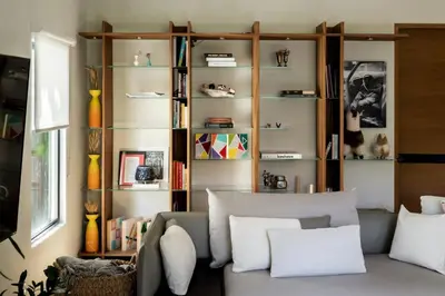 a living room with a couch and a book shelf at NEW! High-End Spanish Duplex | Luxury 3BR in Los Angeles