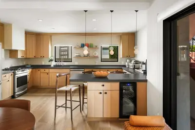 a kitchen with wooden cabinets and a black counter top at NEW! High-End Spanish Duplex | Luxury 3BR in Los Angeles