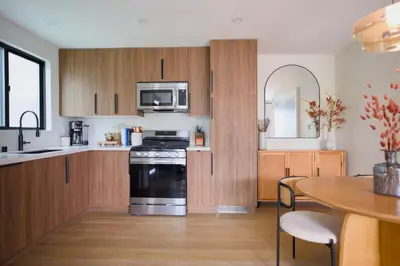 a kitchen with wooden cabinets and a black stove top oven at New Venice Beach Zen Hideaway in Los Angeles