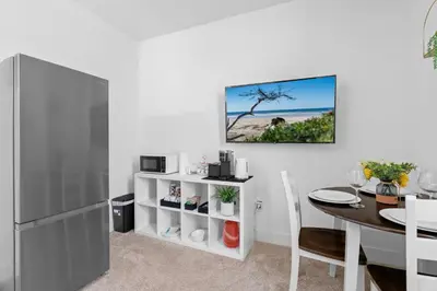 a kitchen and dining room with a table and a refrigerator at Modern 1BR Suite w AC Sleeps 3, NW Bakersfield in Bakersfield