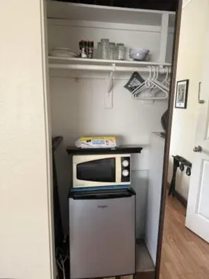 a small kitchen with a microwave on top of a refrigerator at 1140 Alta Loma in Los Angeles
