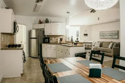a kitchen and living room with a table and chairs at Stunning Home with Pool, Game Room and Firepit in Bakersfield