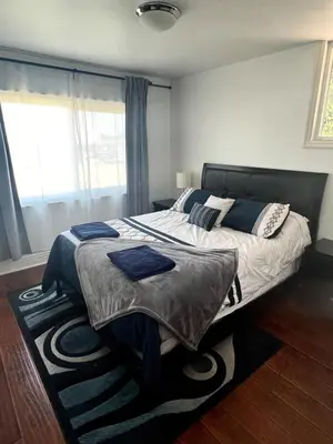 a bedroom with a large bed with blue pillows at Gorgeous Villa with Private Heated Pool in Garnsey