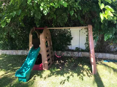 a playground with a slide in the grass at Gorgeous Villa with Private Heated Pool in Garnsey